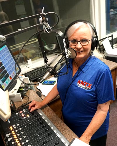 Wendy Hill DJ-ing at the sound board in the radio booth